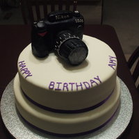 Camera Cake Camera is made of RKT covered in black fondant. Bottom tier is Almond Joy cake with coconut cream filling, top tier is Orange Creamcicle....