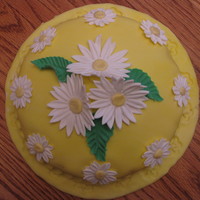 Daisies One layer cake covered in fondant with gumpaste daisies and leaves.