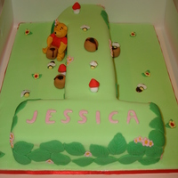 1St Birthday Winnie The Pooh A carved no.1 with fondant decorations. Hunny is brown piping gel.