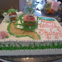 Tinkerbell Cake This is a cake that I did for one of my husband's employee's. Tinkerbell and the big flower is made out of gum paste. The teapot...
