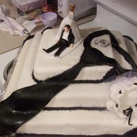 My First And My Own Wedding Cake MMF covered cake with fondant mens necktie, womens garter with fondant and tulle and fondant rings on top. Oh, by the way my husband wanted...