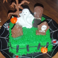 Graveyard Buttercream cake with Tootsie Roll tree, fondant ghost, chocolate modeling clay pumpkin. Graves were made with Wilton's candy mold.