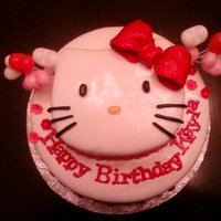 Hello Kitty Cake This is a 10'in 2 layer white cake and the Hello Kitty was carved. The bow,whiskers and flowers are all gumpaste and the eyes and nose...