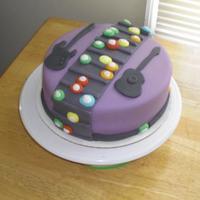 Expert Guitar Hero Player Chocolate fudge cake with strawberry icing and fondant coverings/decorations.