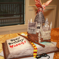 Harry Potter Themed Birthday Cake - Hogwarts Castle With Dragon Harry potter themed birthday cake. All edible materials. The castle is RKT and modeling chocolate, the dragon is gumpaste, the book is cake...