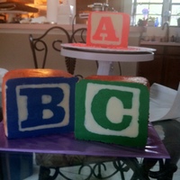 Toy Wooden Baby Blocks This cake was done with 6x6 blocks iced in Buttercream and airbrushed sides. The font plates were created with chocolate in icing bags on...