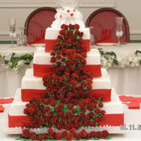 Red And White Square Wedding Cake About 200 gum paste roses on the cake. Red ribbon around the base of the cake.
