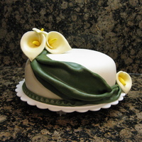 3Rd Anniversary Cake I made this for our 3rd anniversary. The calla lilies are made from gum paste and fondant mixture. The cake is covered in mmf. The drape...