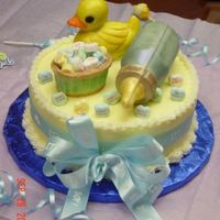 Baby Shower This cake is for a surprised baby shower for a friend at work. Yellow cake covered with buttercream. Rubber duckie, basket, and baby bottle...