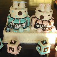 Twins Baby Shower Cake This cake was created to welcome twins. The entire cake is buttercream with handmade fondant and gumpaste accessories such as rattles,...