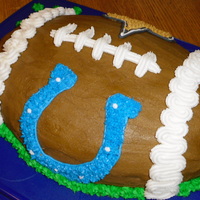 2010 Superbowl Cake I used the Wilton football pan. It's all buttercream. I printed the logos off the computer and used piping gel to trace it on wax...
