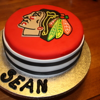 Chicago Blackhawks Two layers of carrot cake with white chocolate ganache icing under fondant. All embelishments are done with fondant and gumpaste.