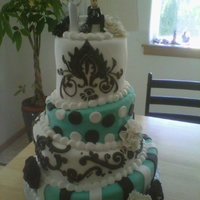 Kind Of Tilted Cake. This was a tilted cake with an untilted top tier (customer wanted it). Covered in fondant with fondant accents and royal icing piping.