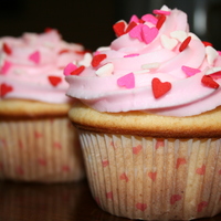 Valentines Cupcakes Vanilla bean cupcakes filled with french custard and iced with buttercream. Valentines Day quins adorn the top.