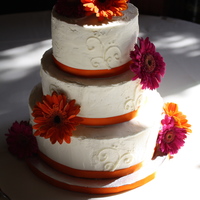 Orange And Fuschia Wedding Cake Buttercream frosting with a delicate scroll design.