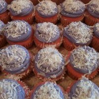 Pink Snowcakes pink tinted coconut cake with coconut creme filling, frosted with purple CC frosting and dusted with snowflake coconut bits and powdered...