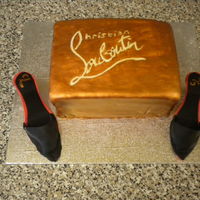 Christian Louboutin Shoe Cake Rectangular cake, painted with edible silk in a bronze colour, with the Christian Louboutin logo stencilled on the top.