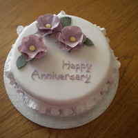 Anniversary Cake With Frills A cake made in my decorating class with sugar paste frills round the side and flower paste flowers on the top.