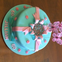 Exploding Cake Blue & pink coloured pettinice covering chocolate mud cake. Icing made to look like an exploding present. Metallic cachous in centre of...