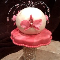 Round Flower Pink & white marble flower shaped base with chocolate & peanut butter round cake with pink gumpaste flowers and matching beading.