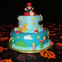 Super Mario Cake 2 tier cake with whipped icing and fondant figures.