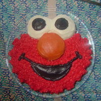Elmo Cake Round cake with cupcakes cut in half for eyes and nose.