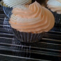 Orange Creamsicle Cuppies Vanilla Bean Cupcake with orange buttercream frosting piped along with marsmallow fluff frosting. Tastes just like an orange creamsicle.