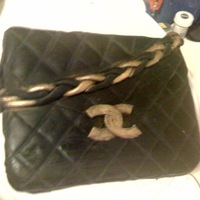 Chanel Purse Cake Dark Chocolate Cake with a Mint Buttercream filling.Covered in Black fondant. Chain handle and Logo embellished with edible gold luster...