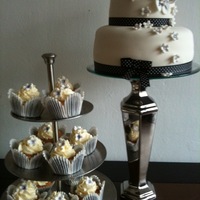 Chic Black and white cake, covered with a mixture of fondant and marzipan, The flowers are made of fondant. Matching strawberry-cream cupcakes...