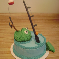 Fishin' Fishing cake for my friend's husband. Buttercream icing, fondant fish, fishing pole, bobber, hook and worm. The fishing line is wire...