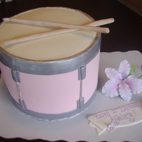 Pink Snare Drum Cake for 15 year old girl in band. Sticks & flower are out of gumpaste. It's a 4 layer 10inch round with supports in the middle.