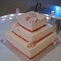 Square Wedding Cake Square wedding cake, white cake with italian buttercream. Decorated with pink ribbon, gumpaste flowers and silver sugar pearls.