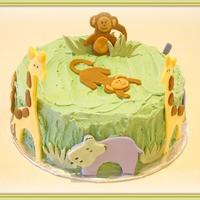 Jungle Theme Baby Shower Cake 10 inch, white cake frosted with buttercream. Decorated with gumpaste animals that were made to match the bedding pattern in baby's...