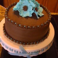 Pain Reliever Chocolate cake, with teal gumpaste flowers. I have the dreaded buldge, but I didn't have time to let it settle. Our neighbor was...