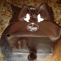 Pure Chocolate Gift Package With Bow Chocolate devils food cake with whipped chocolate and raspberry ganache filling. The outside is covered in modeling chocolate.