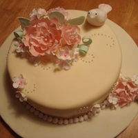Wilton- Gumpaste Class Chocolate cake with ivory fondant (it looks slightly yellow in the photo), gumpaste flowers, pearl sprinkles and a small gumpaste bird.