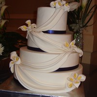 Wedding Cake With Calla Lilies, Fondant Swags And Blue Ribbon 2nd wedding cake!! Gum paste calla lilies, fondant swags and navy blue ribbon as requested by the bride. White chocolate cake with caramel...