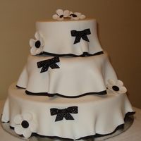 Table Tops Cake design as requested by the bride. Butterscotch cakes covered in MMF with thin black border on bottom. Flowers are gumpaste; bows are...