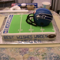 Seahawks Cake this is a cake I did for my bosses going away party. It was 4 sheet cakes with the football helmet cake on top. The helmet is buttercream...