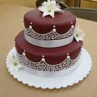 Wilton Course 3 Final Cake Two tier, burgundy fondant with white icing decoration and royal icing lily flowers. Used Wilton burgundy icing color and home-made MMF.