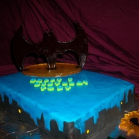 Batman Cake Batman symbol, biff and pow and the yellow oval all out of poured sugar. Everything else is fondant.
