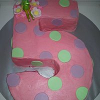 Tinkerbell Pink Buttercream 5 chocolate cake, with choc cream filling, covered in pink buttercream, fondant dots and flowers with toy tinker bell