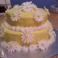 Daisy Cake White cake iced in yellow buttercream with Royal Icing daisies.