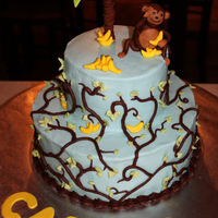 Monkey Cake 2-tier cake with buttercream frosting, with chocolate buttercream vines and buttercream leaves. Topped with fondant palm tree, monkey and...