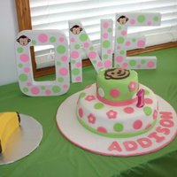 Polka Dot Monkey Cake 2-tier fondant wrapped cake with pink and green polka dots, topped with monkey face