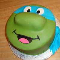 Teenage Mutant Ninja Turtle 8" round covered in MMF with decorations all in fondant. I used a Twinkie for the nose.