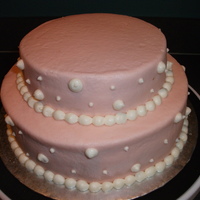 Pink Mini Wedding Cake 1-8" vanilla cake and 1-6" vanilla cake filled with Strawberry Mousee and covered with White Chocolate BC. Borders and dots are...