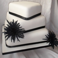 3 Tier Square Black And White Wedding Cake One layer of vanilla sponge and two chocolate covered in sugarpaste and trimmed with black ribbon. Base tier has a diamante trim and the...