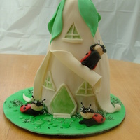 Ladybug's Home Basic Yellow Cake with chocolate frosting covered in MMF. All characters in cake are made out of fondant. Grass is shaved coconut colored...