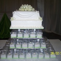 2 Tier Square Cake With Mini Cake Tower 2 tier fruit wedding cake covered with fondant. 120 mini cakes made up the tower in 3 tiers.